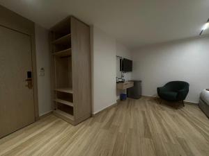 ein leeres Zimmer mit einem Bett und einem Stuhl darin in der Unterkunft Nefertiti Royal Hotel in Kairo