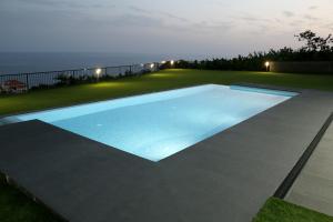 a swimming pool in the middle of a yard at night at Luna Villa in Campanário
