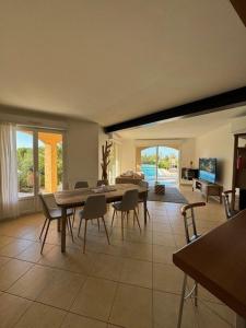 a living room with a dining room table and chairs at Villa avec piscine à quelques minutes de la mer in Lumio