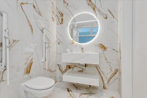 une salle de bain avec des toilettes blanches et un miroir dans l'établissement Candlewood Suites Reykjavik by IHG, à Reykjavik 49 autres photos