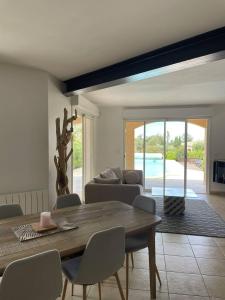 a living room with a wooden table and a couch at Villa avec piscine à quelques minutes de la mer in Lumio +17 photos