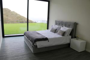 a bedroom with a large bed and a large window at Luna Villa in Campanário +25 photos