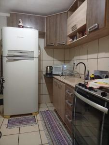 eine Küche mit einem weißen Kühlschrank und einem Herd in der Unterkunft Apartamento Rainha Turquesa in Dourados