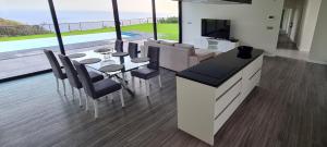 a living room with a dining table and a television at Luna Villa in Campanário