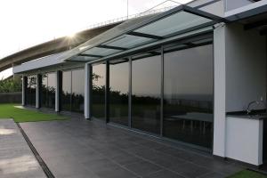 a glass extension of a house with a patio at Luna Villa in Campanário