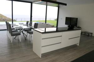 a dining room with a table and a tv at Luna Villa in Campanário