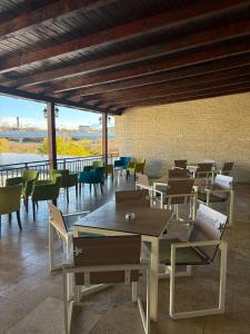 a room with tables and chairs with a view at Hotel Abi in Baile Felix