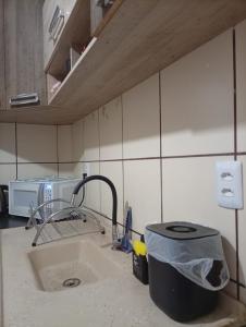 eine Küchentheke mit Spüle und Wasserhahn in der Unterkunft Apartamento Rainha Turquesa in Dourados