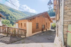 ein Holzgebäude mit einer Veranda und einem Balkon in der Unterkunft Le Grenier - Chalet DDA La Combe in La Combe