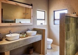 baño con 2 lavabos, espejo y aseo en Motswari Private Game Reserve by NEWMARK, en Reserva Timbavati 87 fotos más