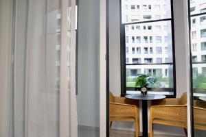 a table and two chairs in a room with a window at Luxe Living Studio in Tirana