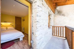 La CombeにあるLa Maison - Chalet DDA La Combeのベッドと石の壁のある寝室