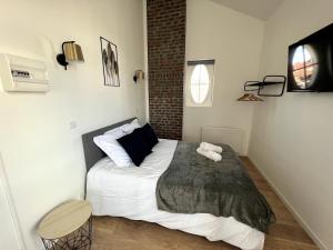 a bedroom with a bed with a stuffed animal on it at Sous les Toits - 2p Centre-ville in Liévin