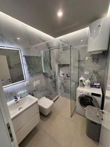 a bathroom with a shower and a toilet and a sink at Sunset Luxury Apartment Shengjin in Lezhë