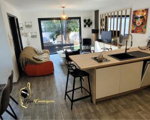 Una cocina y una sala de estar con mesa y sillas. en Dormir à Pinarello Villa 9 pers Piscine chauffée 5 min Plage, en Sainte-Lucie de Porto-Vecchio