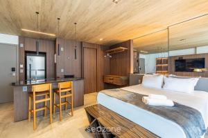 una camera da letto con un letto grande e una cucina di NWTs - Estúdios com Vista Lateral Mar em Maceió IV a Maceió