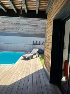 Dormir à Pinarello Villa 9 pers Piscine chauffée 5 min Plage في سانت لوسي دي بورتو فيشيو: حديقة خلفية مع مسبح وسطح خشبي