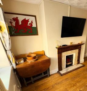 a living room with a fireplace and a flat screen tv at Charming 2 bedroom cottage in Brecon - families and pets welcome! in Brecon