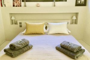 a bedroom with a bed with two pillows on it at La Matina Family Haven with Olive Garden Oasis in Lauris