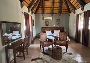 ルンドゥにあるNgandu Hotel - Runduのベッドとテーブルと椅子のある寝室