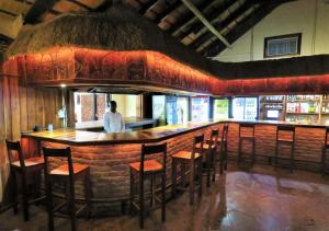 ルンドゥにあるNgandu Hotel - Runduのレストランのバーに立つ男