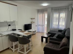 a kitchen and living room with a couch and a table at Holiday Apartmens Neli in Shëngjin