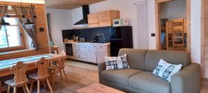 a living room with a couch and a table and a kitchen at My Sweet Home in the Dolomites - appartamento "Ai Vòlti" in Cavalese