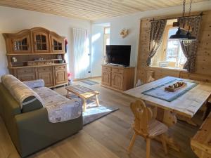 a living room with a couch and a table at My Sweet Home in the Dolomites - appartamento "Ai Vòlti" in Cavalese