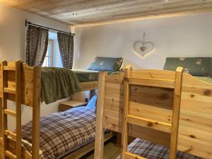 a bedroom with two bunk beds and a heart on the wall at My Sweet Home in the Dolomites - appartamento "Ai Vòlti" in Cavalese