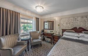 a bedroom with a bed and a desk and a chair at Riverside Inn in Ely