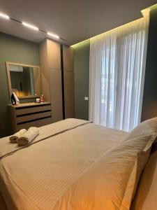 レジャにあるSunset Luxury Apartment Shengjinの窓のある大きな白いベッドのある寝室