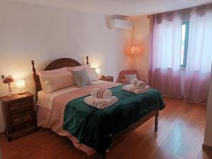 Un dormitorio con una cama con dos toallas encima. en Casa Vitral - Stained Glass House, en Miranda do Douro