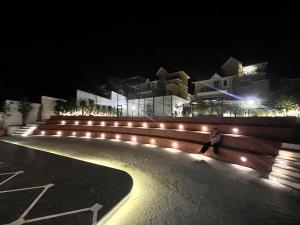 a person walking down a sidewalk at night with lights at Comfort Stay Calangute beach Goa in Serula