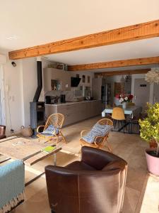 a living room with a couch and chairs and a kitchen at Maison 6 places, en plein cœur de l’Ariège, proche ski et nature in Lesparrou