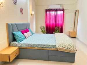 a bedroom with a bed with colorful pillows on it at Comfort Stay Calangute beach Goa in Serula +30 photos