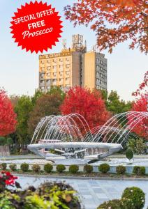 a fountain in a park in front of a building at Hotel Cetate in Alba Iulia
