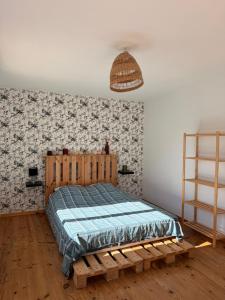 a bedroom with a bed with a wooden bed frame at Maison 6 places, en plein cœur de l’Ariège, proche ski et nature in Lesparrou