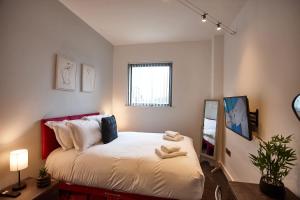 a bedroom with a bed with two towels on it at The Rose Quartz Suite in Manchester +40 photos