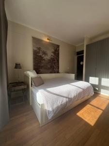 a bedroom with a large white bed and a table at Suite studio Darcy in Dijon