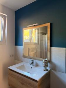 a bathroom with a sink and a mirror at Maison 6 places, en plein cœur de l’Ariège, proche ski et nature in Lesparrou
