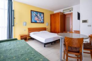 カヴァッリーノ・トレポルティにあるEurobeach Residenceのベッドルーム1室(ベッド1台、テーブル、ベッド1台付) +47枚の写真