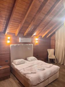 een slaapkamer met een groot wit bed met een houten plafond bij Real Love Villas in Sakarya