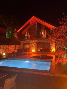 een zwembad voor een huis 's nachts bij Real Love Villas in Sakarya