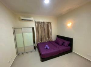 a bedroom with a purple bed and a window at Tiara Homestay Desaru - Nature view in Bandar Penawar