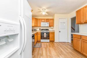 a kitchen with wooden cabinets and a white refrigerator at Reilly Road Refuge in Fort Bragg