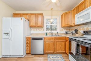 a kitchen with wooden cabinets and a white refrigerator at Reilly Road Refuge in Fort Bragg