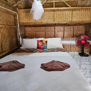 un letto in una stanza con due accappatoi sopra di Long beach simple House a Ko Lanta Altre 113 foto