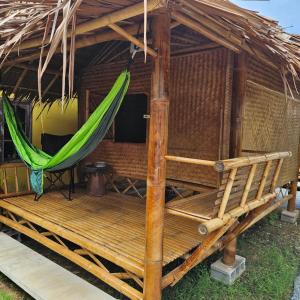 a hammock on a deck with a thatch hut at Long beach simple House in Ko Lanta