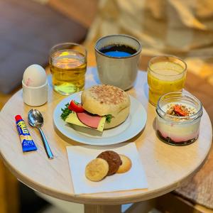 a table with a sandwich on a plate and drinks at Hotel With Urban Deli in Stockholm