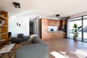 ein Wohnzimmer mit Couch und Küche in der Unterkunft Droomsuites Egmond aan Zee 4 personen by Droomvilla in Egmond aan Zee